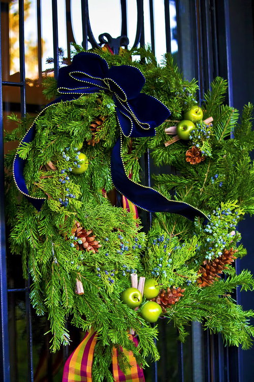 黒い門に飾られた青いリボンのクリスマスリース