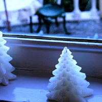 窓辺に並ぶ白い樹脂製のクリスマスツリー飾りの写真