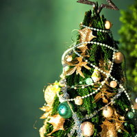 金色の星と飾りが付いた小さいクリスマスツリーの写真