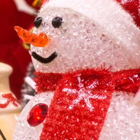 赤い帽子をかぶった透明な雪だるまの人形の写真