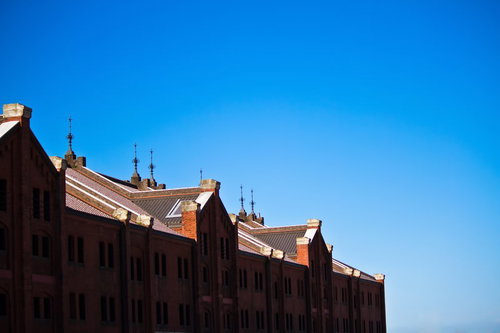 快晴の青空の下に建つ赤レンガの集合住宅