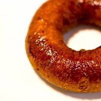 白い台の上に置いた光沢のある甘そうなドーナツの写真