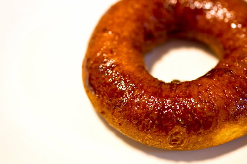 白い台の上に置いた光沢のある甘そうなドーナツ