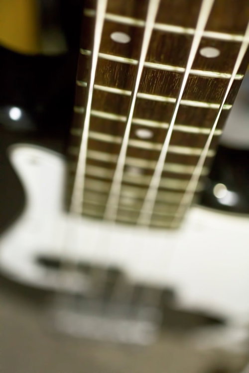 フレットとポジションマークが見えるベースのネックと弦