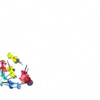 白い面の上に散らばったカラフルな透明の画鋲の写真