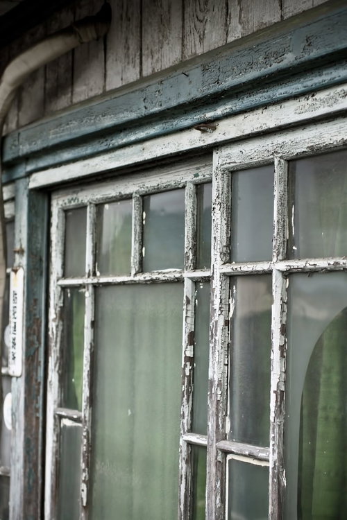 ペンキが剥がれた木枠の古くボロボロな窓