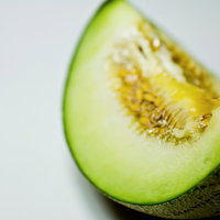 種が見える断面にカットされた緑のメロンの写真