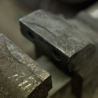 傷や汚れが残る工具台の上の金属の万力の写真