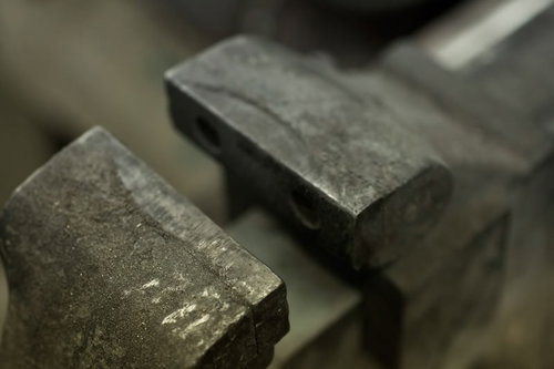 傷や汚れが残る工具台の上の金属の万力