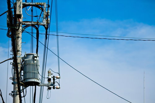 変圧器と電線が付いた真夏日の電柱と入道雲の青空