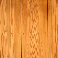 温かい照明に照らされた縦並びの木目の板の写真