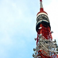 下から見上げた天辺が曲がった東京タワーの鉄骨の写真