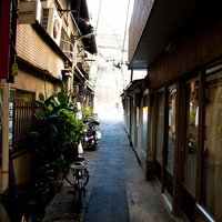 自転車やバイクが停まる下町の路地裏の風景の写真