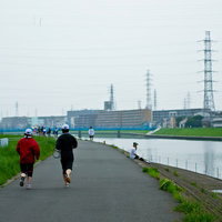 川沿いの舗装路を走る河川敷のランニングコースの写真
