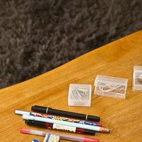 松ぼっくりやペンが散らばるテーブルの上の小物の写真