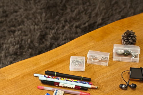 松ぼっくりやペンが散らばるテーブルの上の小物