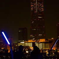 窓明かりが並ぶ夜のランドマークタワーと恋人のシルエットの写真