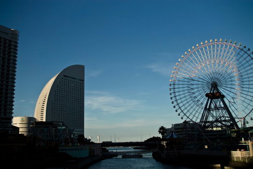 夕暮れの観覧車と高層ビルが映るみなとみらいの水辺