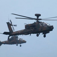迷彩の2機が飛ぶ総火演のAH-64DとOH-1ヘリの写真