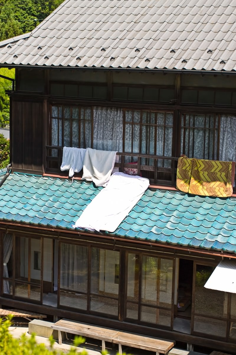 瓦屋根に布団を干した日本家屋