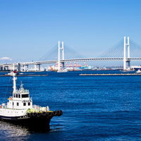 タグボートが航行するベイブリッジと青い海の風景の写真