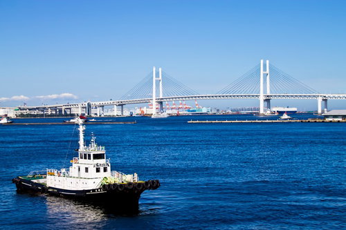 タグボートが航行するベイブリッジと青い海の風景