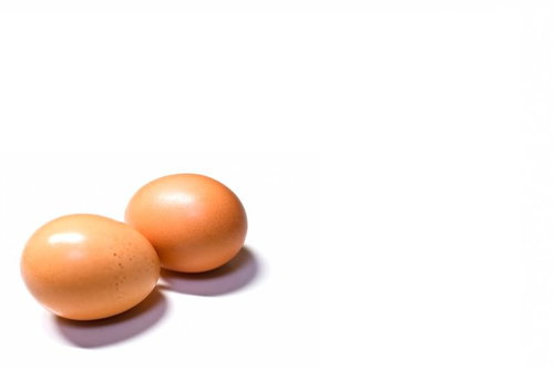 白い台の上に並べた2個の茶褐色のたまご