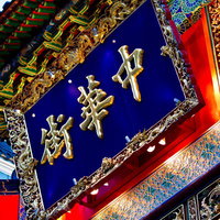 金色の漢字と銀の龍が飾る横浜中華街の看板の写真