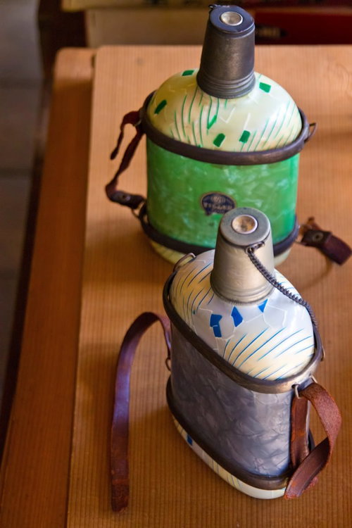 木のテーブルに並べた2つのレトロな古い水筒