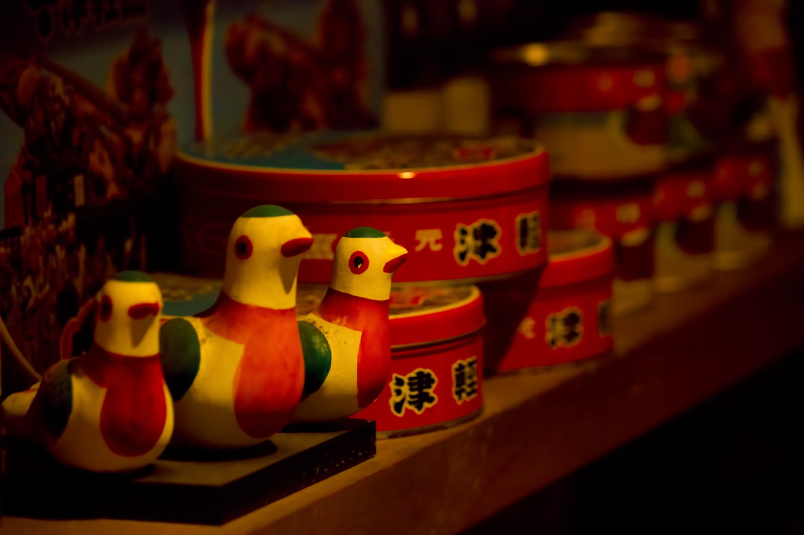 津軽の鳥型置物と缶のお土産が棚に並ぶ