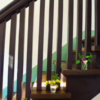 室内の階段に花を飾った透明なガラス容器の写真