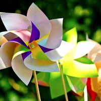 木の棒に刺さったカラフルな紙の風車が並ぶの写真