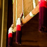 赤白黒の房飾りが付いた境内の巻きすだれの写真