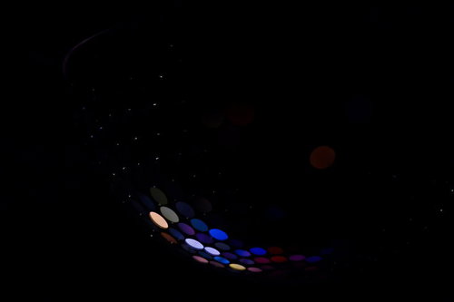 暗闇に浮かぶ青やピンクに光るミラーボールの球体