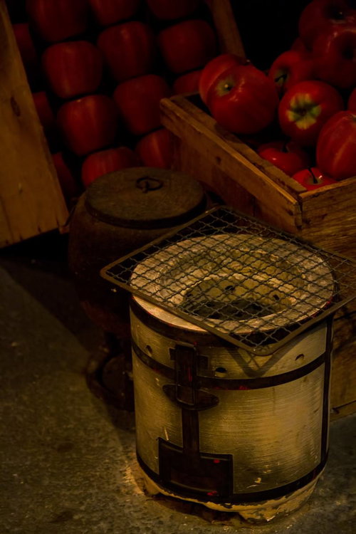 リンゴと並ぶ昔懐かしい七輪と薄切り食材の網焼き