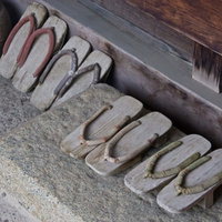 石の台に色とりどりの鼻緒の下駄が7足並ぶの写真