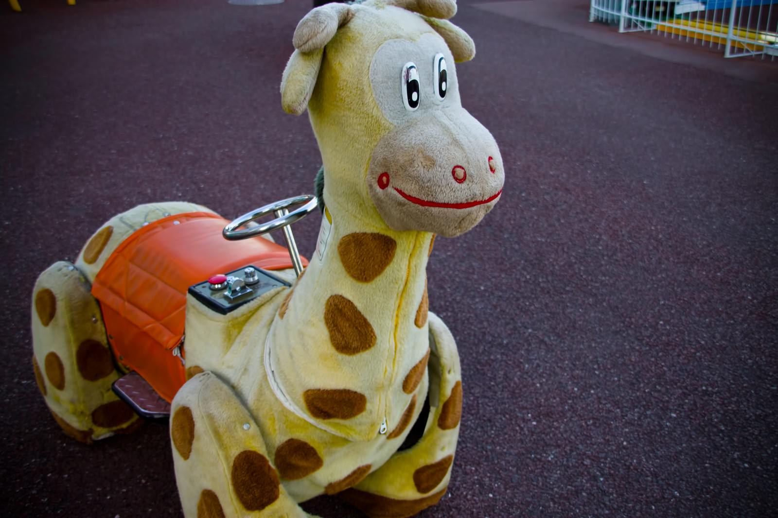 コイン投入口が付いた黄色いキリンのぬいぐるみ乗り物