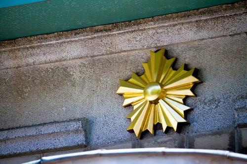 コンクリート壁に付いた金色の星形の交番桜のエンブレム