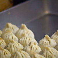 灰色の器にひだ模様の生地で包んだ手作り小籠包の写真