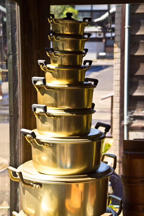 大きい順に縦に積み重ねた8個の金色の鍋