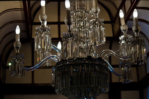 ろうそく型電球が灯る大きなガラスのシャンデリア