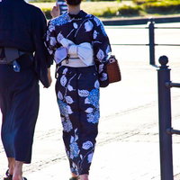 日傘をさしかごバッグを持つ浴衣の恋人の後ろ姿の写真