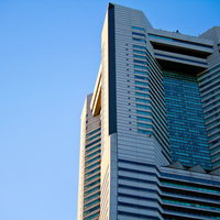 青空に映える夕暮れのランドマークタワー上部の写真