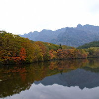 紅葉が水面に映り込む戸隠の鏡池と山並みの写真