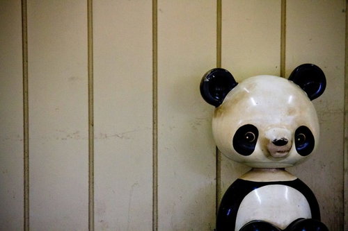 壁際に置かれた朽ちたパンダの遊具