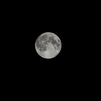 真っ黒な夜空に浮かぶ中秋の名月の満月の写真