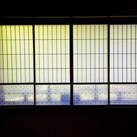 青紫の模様が入った障子戸が4枚並ぶ和室のガラス戸の写真