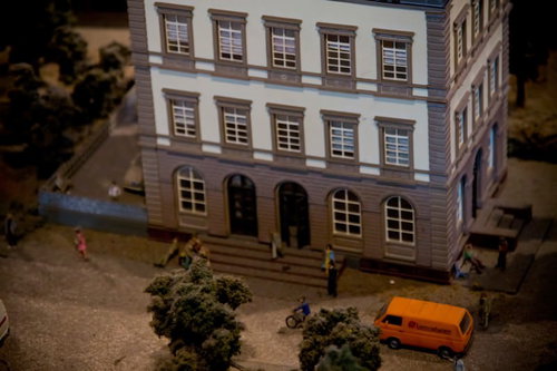 小さな人形と自転車が並ぶホテル前のミニチュアジオラマ