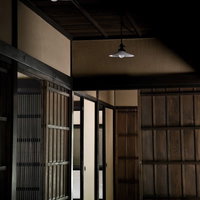 白い傘型照明が灯る古い木造建築の座敷の入口の写真