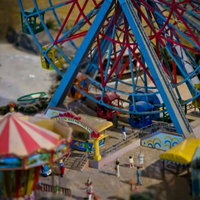 観覧車とメリーゴーランドが並ぶ遊園地のミニチュア模型の写真